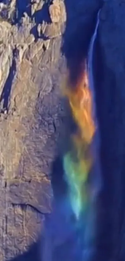 Rainbow waterfall against rocky cliffs with vivid colors.