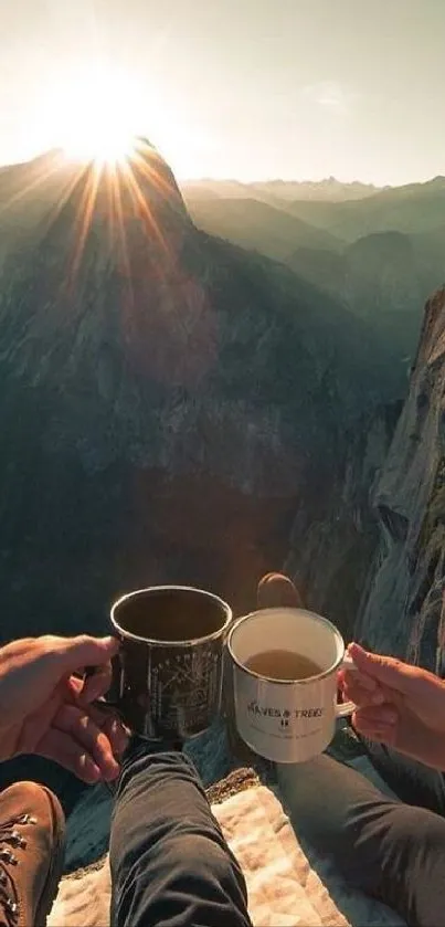 Two people enjoying sunrise over a mountain cliff with coffee cups.