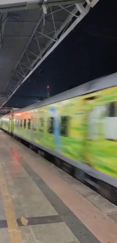 Green train speeding through a nighttime train station.