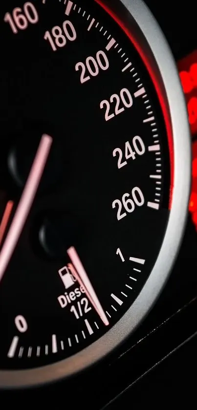 Close-up image of a sleek speedometer with red accents in a car dashboard.