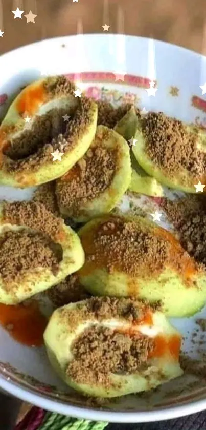 Green guavas with chili powder and sauce in a decorative bowl.