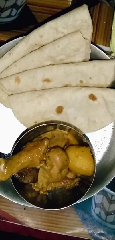 Plate of spicy curry and flatbread in vibrant Indian cuisine display.