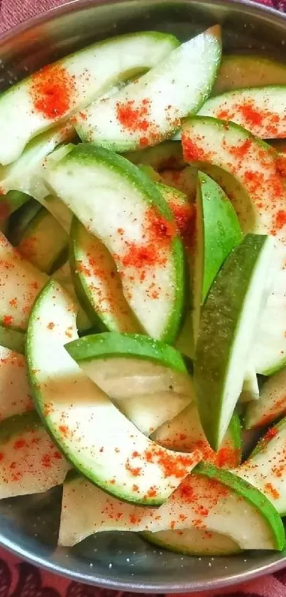 Sliced mango sprinkled with chili powder on red fabric.