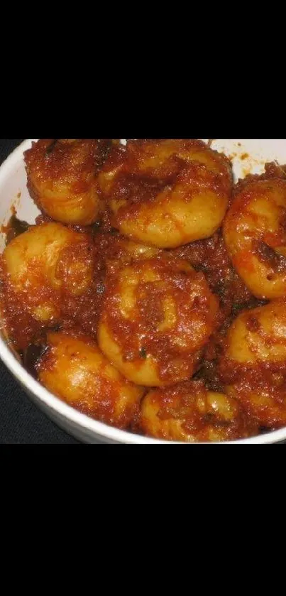 Spicy potato dish in a white bowl, vibrant wallpaper.