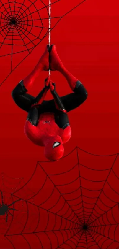 Upside-down superhero against red web backdrop.