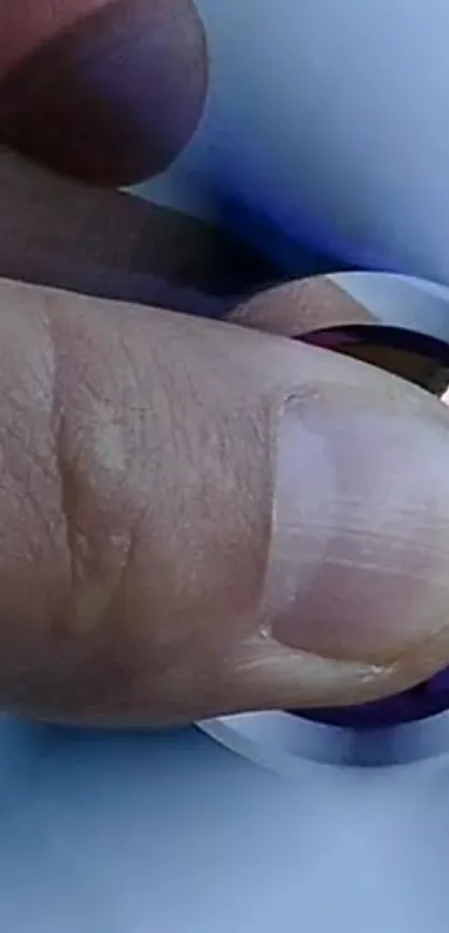 Close-up of a hand spinning a fidget spinner with a blue background.