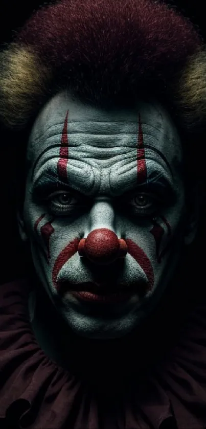 Dark, spooky clown face with striking makeup and shadows in a mobile wallpaper.