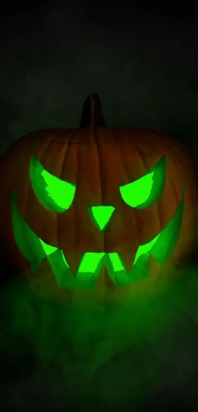 Glowing green Jack-o'-lantern in dark misty background.