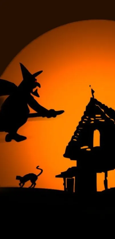 Silhouette of a witch flying before a glowing orange full moon on Halloween night.