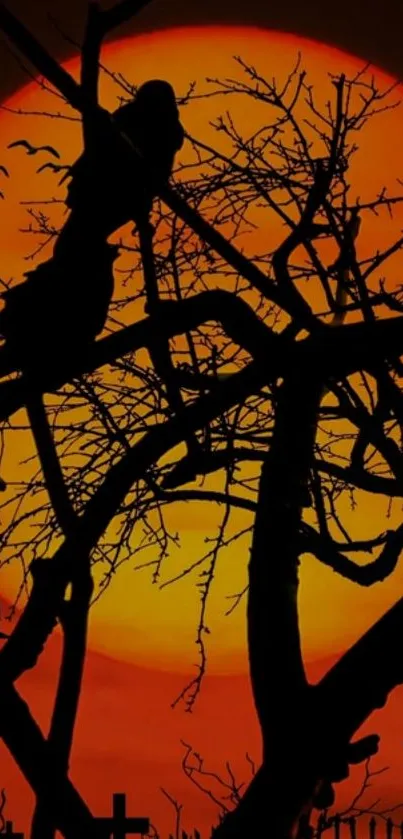 Halloween-themed silhouette against a vivid orange sunset.