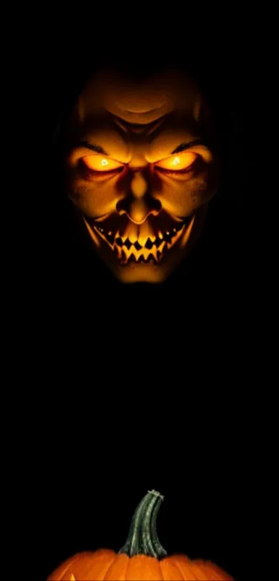 Dark wallpaper with glowing pumpkin and scary face.