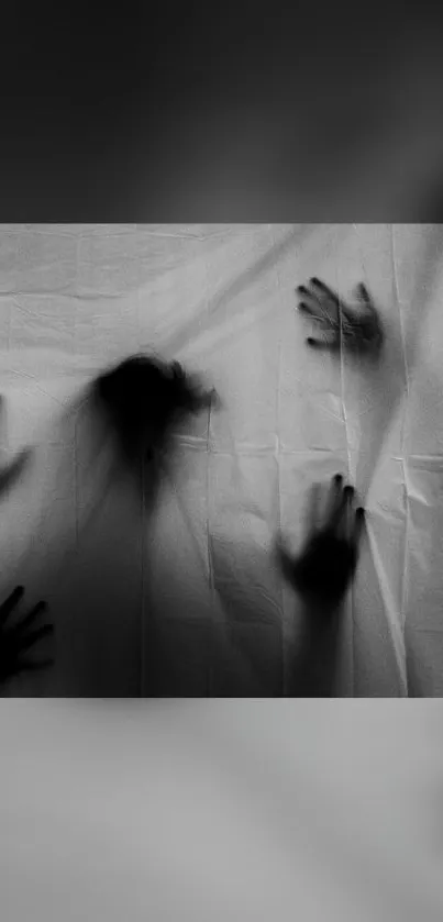 Black and white wallpaper with shadowy hands on a curtain for a spooky effect.