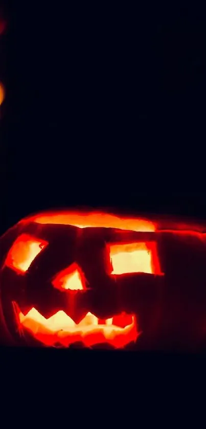 Glowing jack-o'-lantern against a dark background.