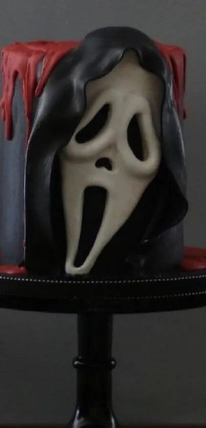 Spooky mask cake with dark eerie design on a stand.