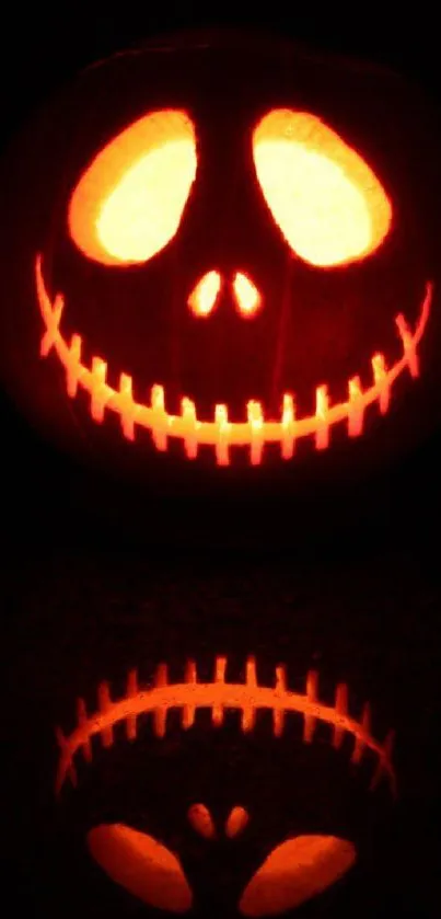 Glowing jack-o'-lantern with reflection on dark background.