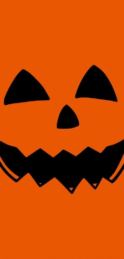 Orange Halloween pumpkin face with black features on mobile wallpaper.