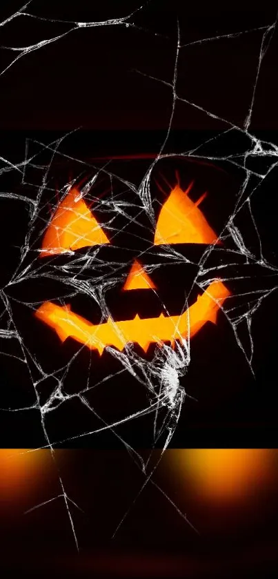 Spooky pumpkin face with spiderwebs on a Halloween-themed wallpaper.