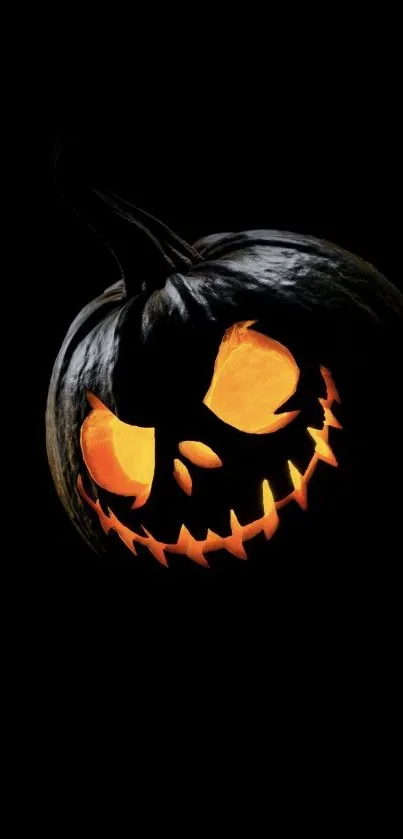 Halloween wallpaper with a glowing, carved pumpkin on a black background.