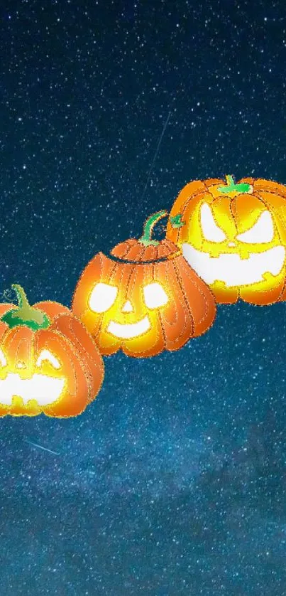 Glowing carved pumpkins float against a starry dark blue night sky.