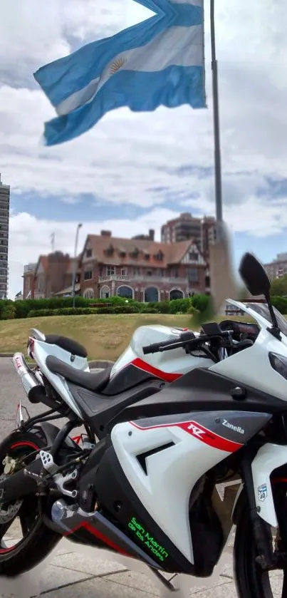 Sport bike parked under Argentine flag with urban backdrop.