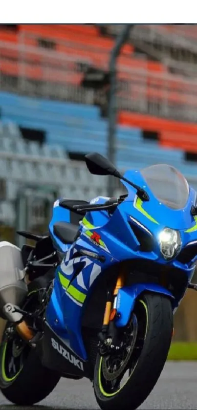 A blue sportbike on a vibrant racing track, perfect for mobile wallpaper.