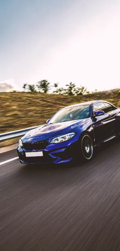 Blue sports car racing along a scenic road at sunset.