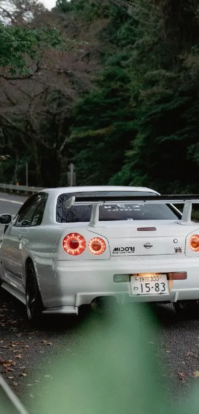 White sportscar on green mountain road.