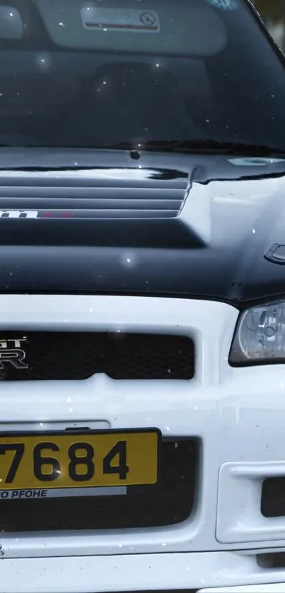 Front view of a sporty black and white car with detailed headlights.