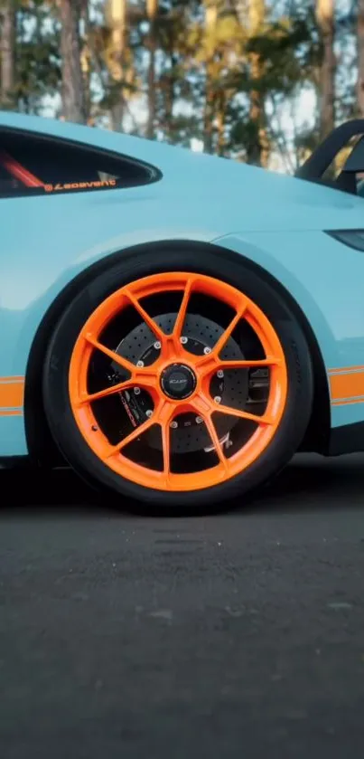 Sporty car with vibrant orange wheel parked.