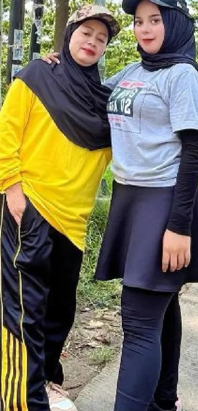 Two women in sporty hijab fashion outdoors.