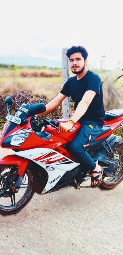 A person sitting on a red motorcycle on an open road.