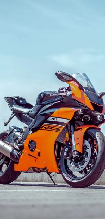 Vibrant orange and black motorcycle wallpaper on a clear day.