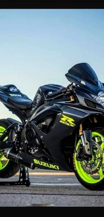 Sporty black motorcycle with neon green wheels on a road.