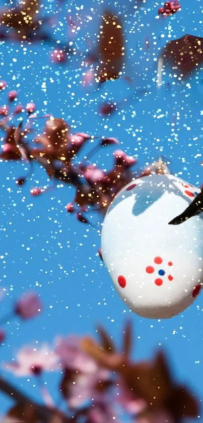 Easter egg and blossoms against a bright blue sky.