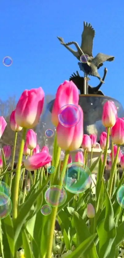 Pink tulips with bubbles under a blue sky and garden sculpture.