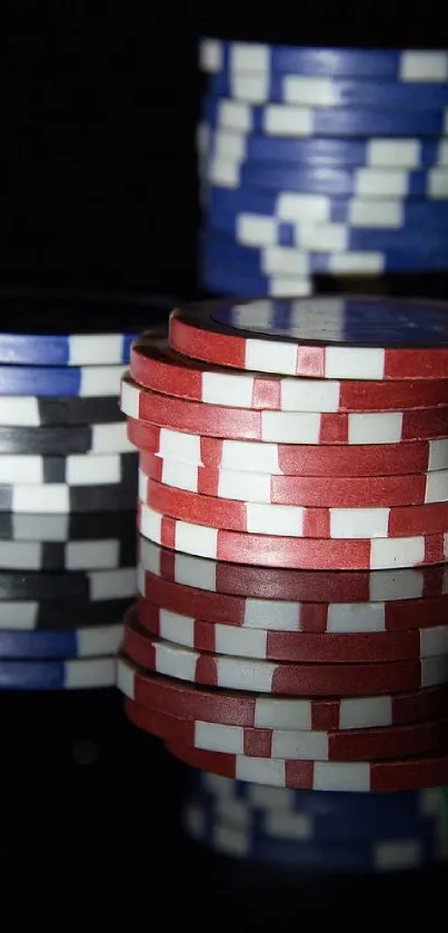 Mobile wallpaper featuring colorful casino chips stacked on a black background.