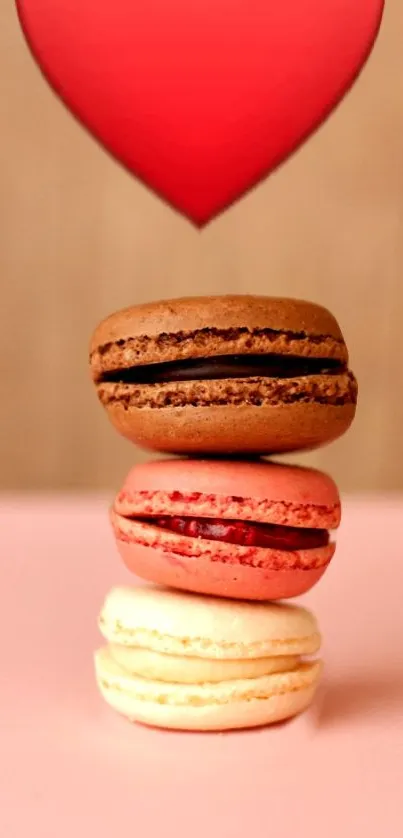 Stack of macarons with a red heart, on pink background.