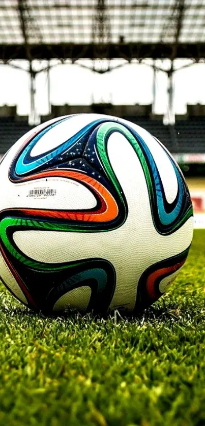 Soccer ball on green stadium field wallpaper.