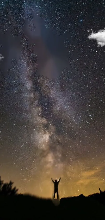 Silhouette under the starry Milky Way sky with vibrant cosmic colors.