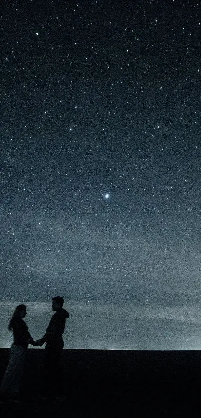 Couple silhouette holding hands under a starlit night sky.