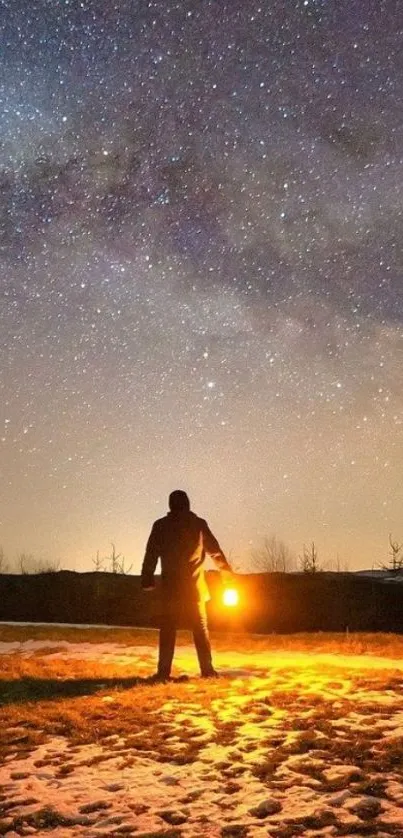 Silhouetted figure under a starry night sky holding a glowing light.