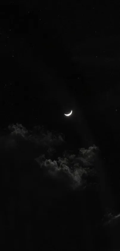 Crescent moon and clouds in a dark night sky.