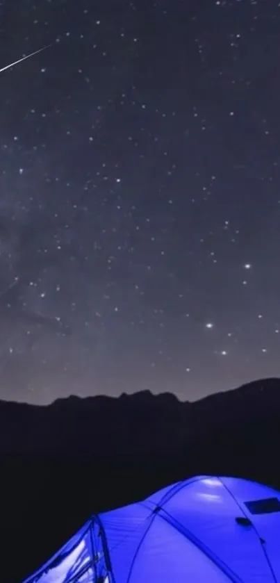 Starry night sky with glowing tent at campsite.