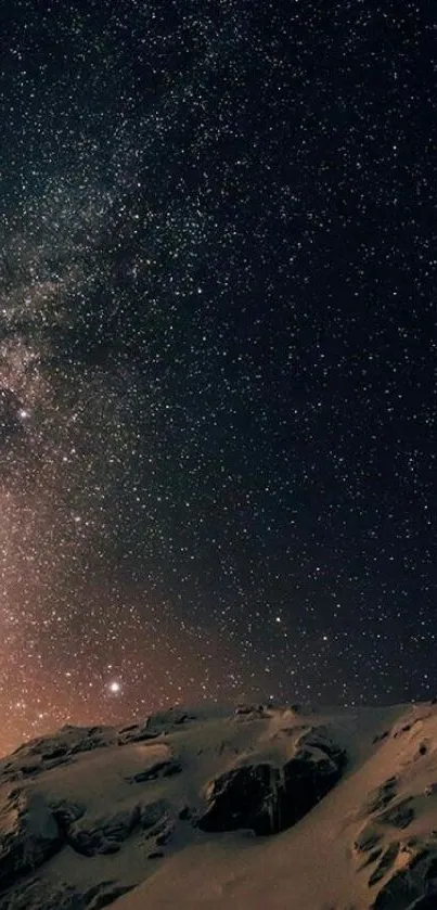 Starry night sky over snow-covered mountains.