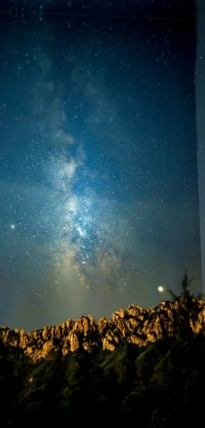 Starry night sky over mountain landscape with Milky Way.