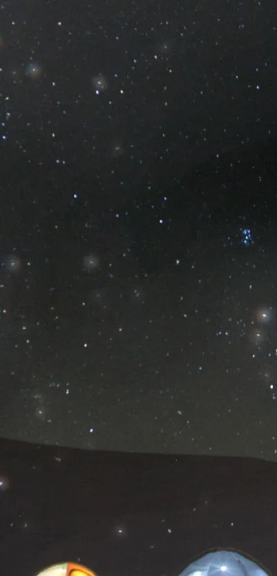 Starry night sky over a camping scene with tents.