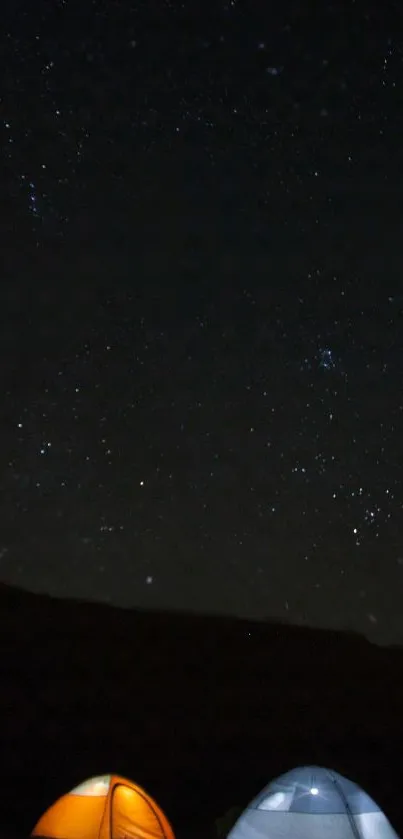 Starry night sky with two glowing camping tents under the stars.