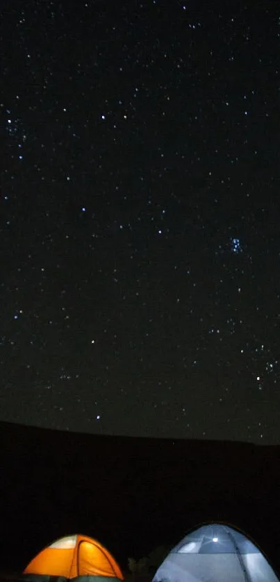 Starry night sky over glowing tents in a serene outdoor setting.