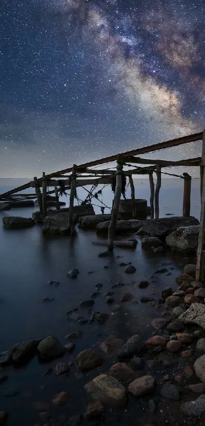 Starry night sky over calm waters with an old pier.