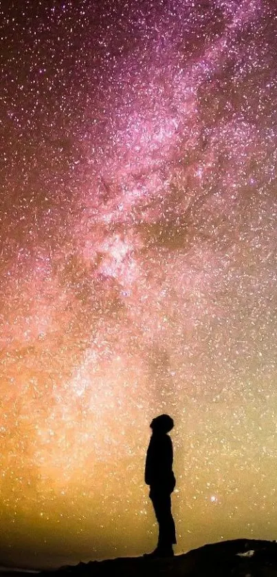 Silhouette gazing at a vibrant, starry galaxy night sky.